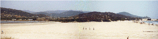La grande spiaggia di sabbia chiara, con l'area di sosta a sinistra