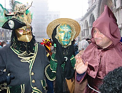 Un frate 'sui generis' benedice una coppia di curatissime maschere Veneziane, come si evince dal copricapo di sinistra